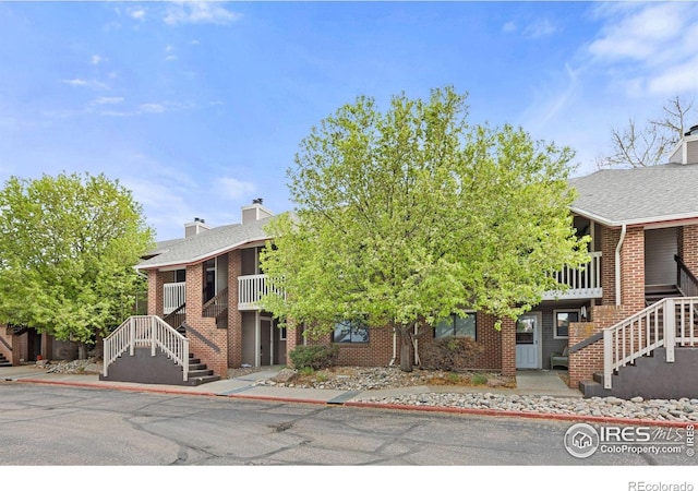1231 W Swallow Rd Unit 314, Fort Collins, CO 80526 - view of front facade featuring stairs, brick siding, and a chimney