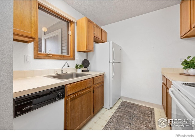 1231 W Swallow Rd Unit 314, Fort Collins, CO 80526 - kitchen featuring white appliances, light floors, light countertops, a textured ceiling, and a sink