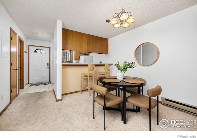 1231 W Swallow Rd Unit 314, Fort Collins, CO 80526 - dining room featuring light colored carpet, an inviting chandelier, a textured ceiling, baseboards, and a baseboard radiator