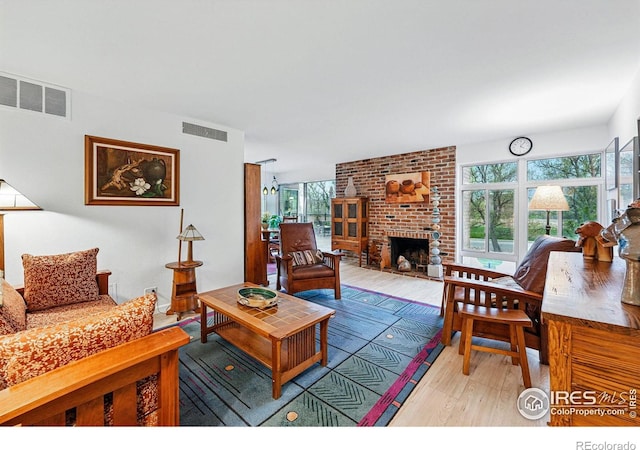living room featuring visible vents, plenty of natural light, and wood finished floors