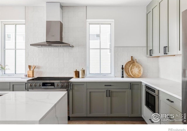 914 Eldorado Ln, Louisville, CO 80027 - kitchen featuring wall chimney range hood, gray cabinets, tasteful backsplash, light stone countertops, and stainless steel electric range