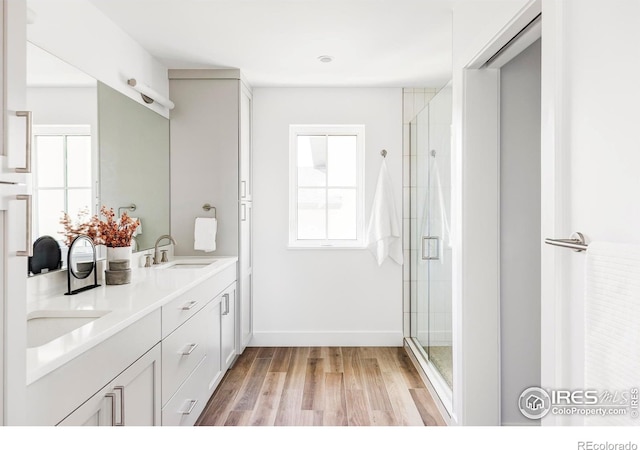 914 Eldorado Ln, Louisville, CO 80027 - bathroom with double vanity, a stall shower, wood finished floors, a sink, and baseboards
