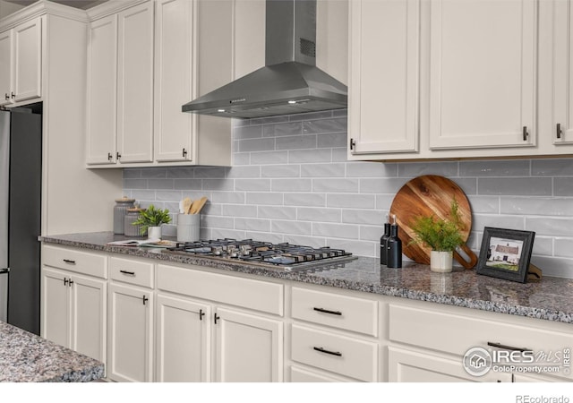 5845 Shadow Creek Ct, Windsor, CO 80528 - kitchen with wall chimney exhaust hood, stainless steel appliances, white cabinets, stone countertops, and decorative backsplash