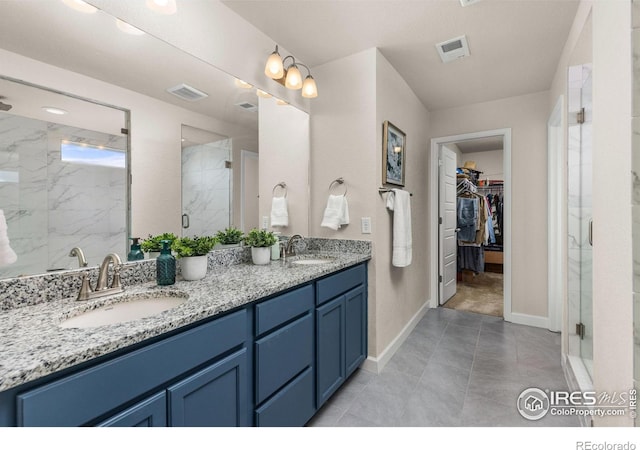 5845 Shadow Creek Ct, Windsor, CO 80528 - bathroom featuring double vanity, a marble finish shower, a spacious closet, and baseboards