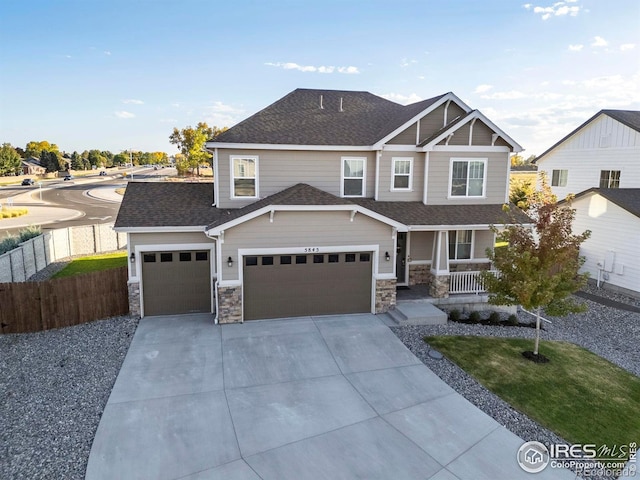 5845 Shadow Creek Ct, Windsor, CO 80528 - craftsman house featuring covered porch, driveway, a shingled roof, an attached garage, and stone siding