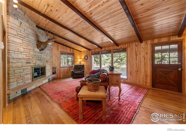 565 Hemlock Dr, Lyons, CO 80540 - living area with wood walls, a stone fireplace, vaulted ceiling with beams, wood ceiling, and hardwood / wood-style flooring