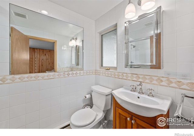 565 Hemlock Dr, Lyons, CO 80540 - bathroom with visible vents, tile walls, a shower with shower door, vanity, and toilet