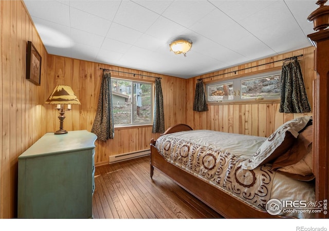 565 Hemlock Dr, Lyons, CO 80540 - bedroom featuring wood walls, a baseboard heating unit, and hardwood / wood-style flooring