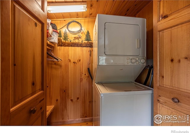 565 Hemlock Dr, Lyons, CO 80540 - clothes washing area with wood ceiling, stacked washer and clothes dryer, and wood walls