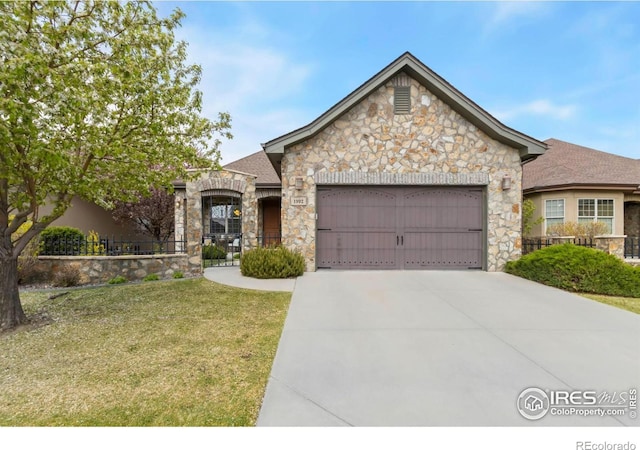 1992 Vineyard Dr, Windsor, CO 80550 - french country inspired facade featuring a garage, a front lawn, fence, stone siding, and concrete driveway
