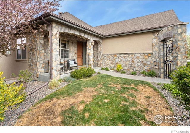 1992 Vineyard Dr, Windsor, CO 80550 - view of front facade with covered porch, a shingled roof, and stone siding
