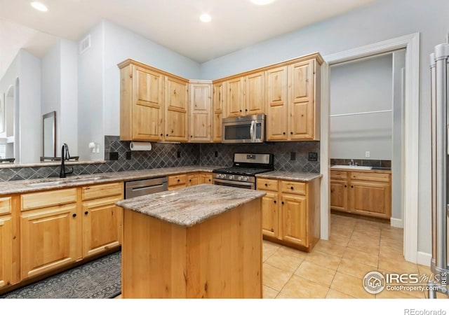 1992 Vineyard Dr, Windsor, CO 80550 - kitchen featuring a sink, light stone counters, decorative backsplash, and stainless steel appliances