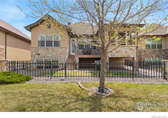 1992 Vineyard Dr, Windsor, CO 80550 - view of front of property featuring a fenced front yard, a balcony, stone siding, and stucco siding
