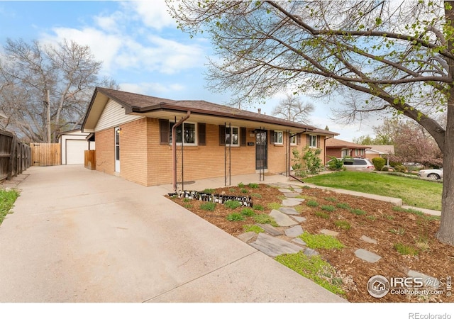 9261 Julian Way, Westminster, CO 80031 - view of front of property featuring fence, a front lawn, brick siding, a detached garage, and an outdoor structure