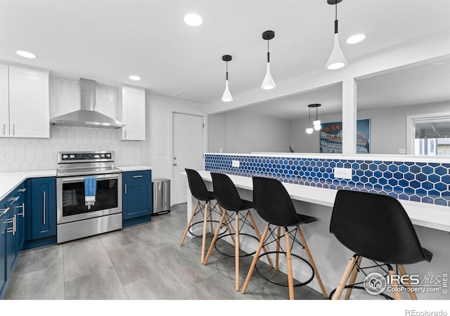 9261 Julian Way, Westminster, CO 80031 - kitchen with electric range, a kitchen breakfast bar, wall chimney range hood, light countertops, and blue cabinets