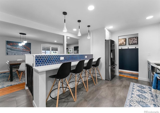 9261 Julian Way, Westminster, CO 80031 - kitchen with high end refrigerator, light countertops, white cabinets, a peninsula, and recessed lighting