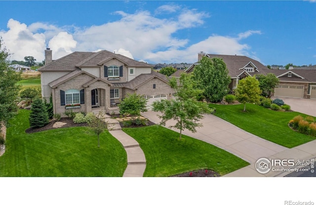 view of front of property featuring concrete driveway, a chimney, a front yard, and a garage