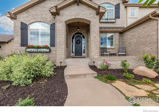 view of exterior entry featuring brick siding