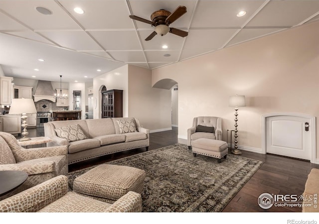 living area featuring baseboards, dark wood-style floors, recessed lighting, arched walkways, and ceiling fan with notable chandelier