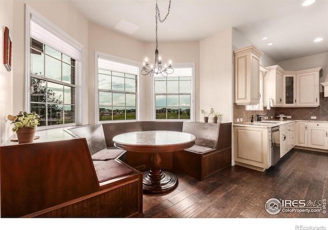 interior space with dark wood-type flooring, recessed lighting, breakfast area, and a notable chandelier
