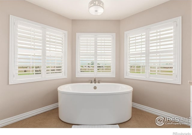 bathroom with baseboards and a freestanding bath