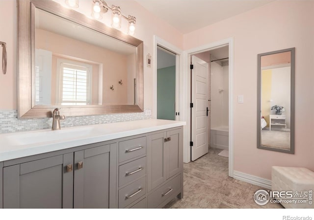 full bathroom featuring backsplash, baseboards, bathing tub / shower combination, and vanity