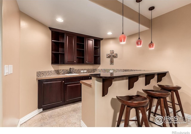 bar with recessed lighting, baseboards, hanging light fixtures, and a sink