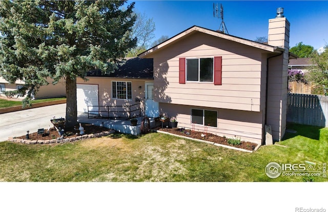 743 43rd Ave, Greeley, CO 80634 - tri-level home featuring an attached garage, a chimney, and a front lawn