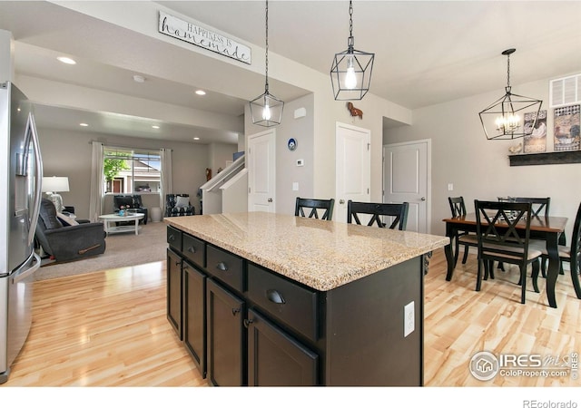 3803 Peach St, Wellington, CO 80549 - kitchen featuring stainless steel refrigerator with ice dispenser, light wood-style flooring, a chandelier, pendant lighting, and recessed lighting