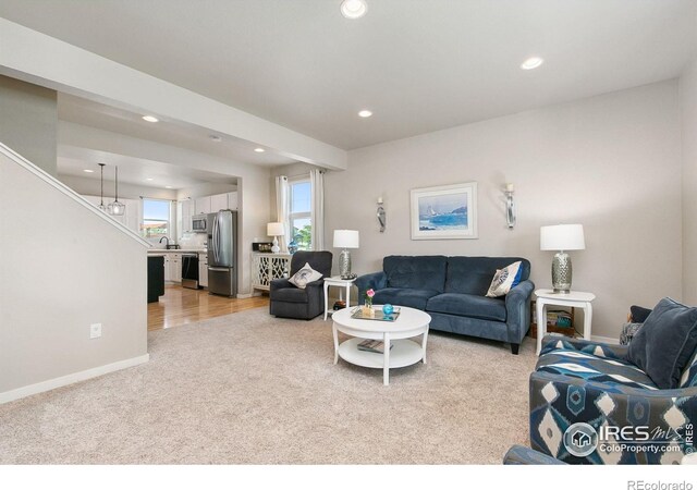 3803 Peach St, Wellington, CO 80549 - living room with light colored carpet, recessed lighting, baseboards, and stairway