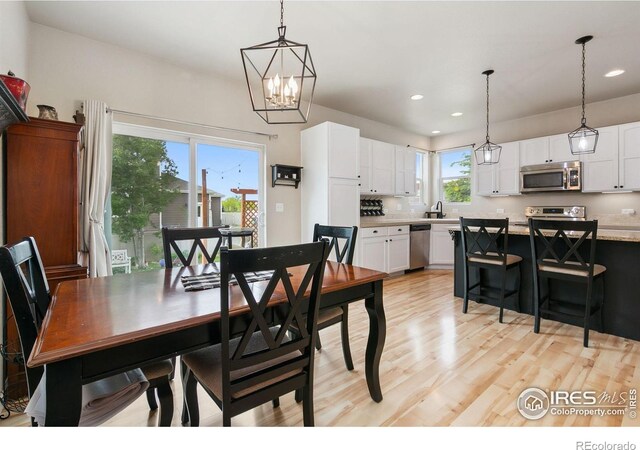 3803 Peach St, Wellington, CO 80549 - dining room with light wood-style flooring, a chandelier, and recessed lighting