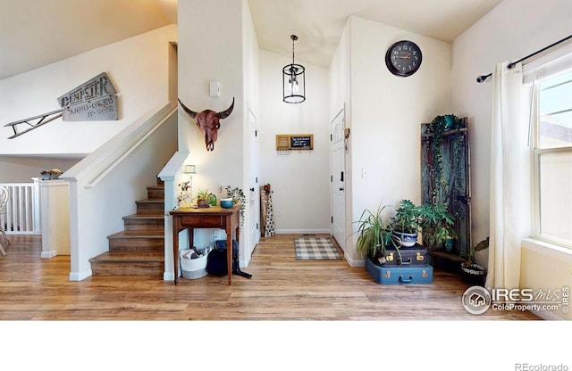 foyer entrance with baseboards, stairs, and wood finished floors
