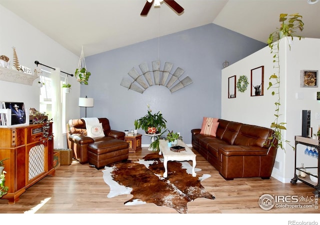 living room with a ceiling fan, vaulted ceiling, and wood finished floors