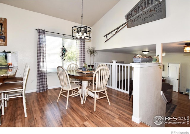 dining room featuring baseboards, vaulted ceiling, wood finished floors, and a notable chandelier