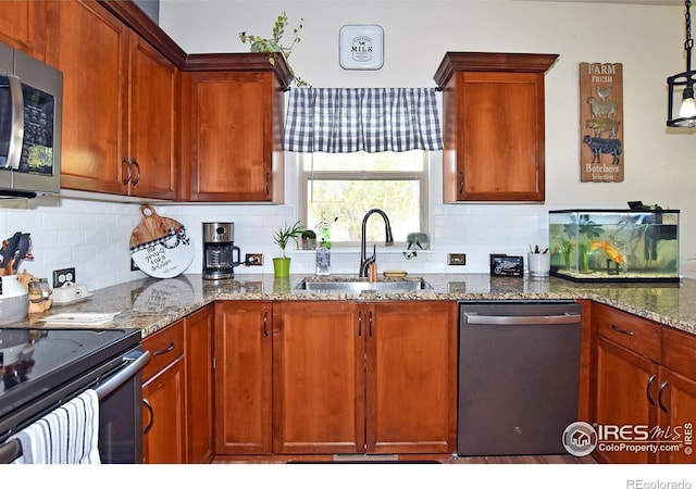 kitchen with a sink, stone countertops, backsplash, and stainless steel appliances