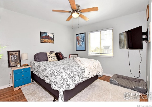 bedroom featuring baseboards, a ceiling fan, and wood finished floors