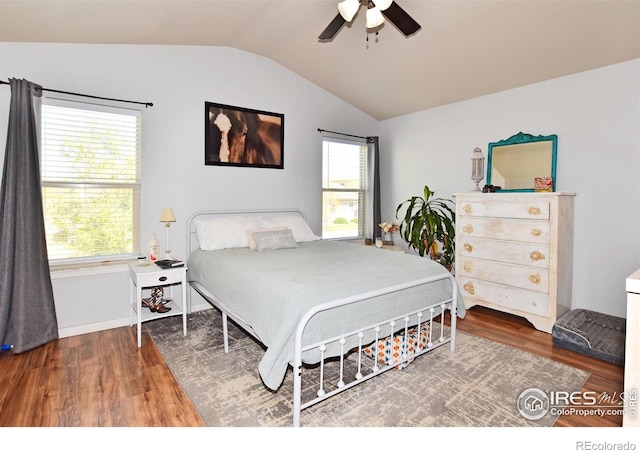 bedroom with ceiling fan, multiple windows, vaulted ceiling, and wood finished floors