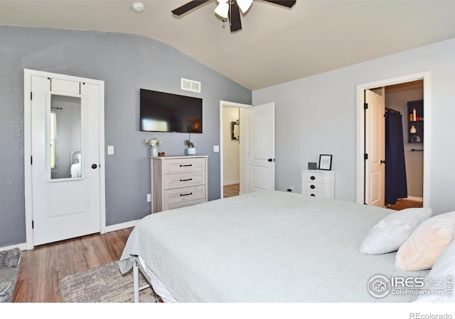 bedroom with a ceiling fan, visible vents, vaulted ceiling, wood finished floors, and baseboards