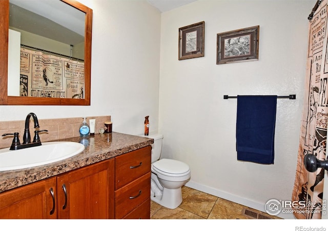 bathroom with toilet, baseboards, tile patterned flooring, and vanity