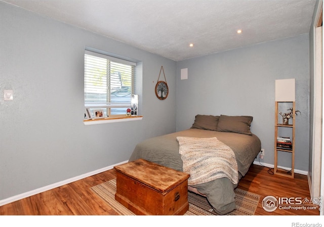 bedroom with baseboards and wood finished floors