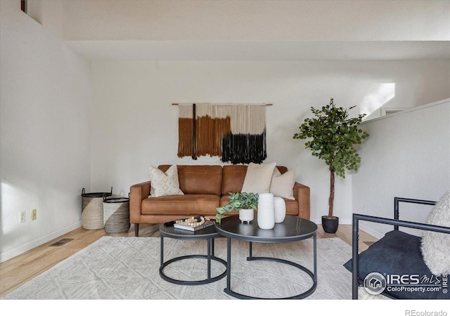 living room with baseboards, wood finished floors, and visible vents