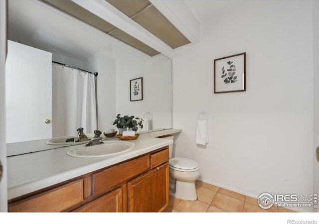 bathroom featuring toilet, tile patterned floors, baseboards, and vanity