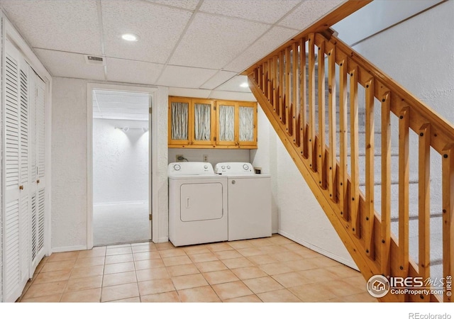 laundry room with cabinet space, baseboards, a textured wall, recessed lighting, and washer and dryer