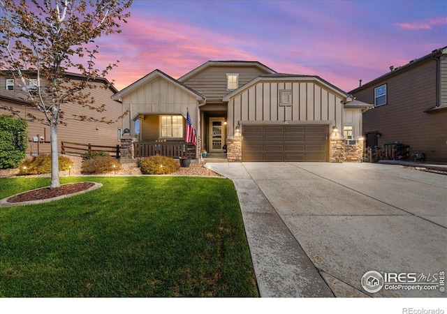 single story home with a lawn, board and batten siding, driveway, covered porch, and stone siding
