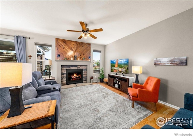 living area with baseboards, a healthy amount of sunlight, ceiling fan, and wood finished floors
