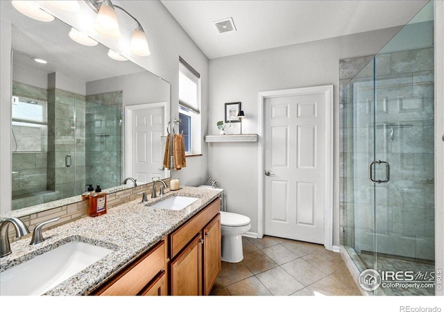 bathroom featuring visible vents, tile patterned flooring, a shower stall, and a sink