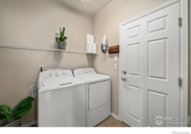 laundry room featuring laundry area, independent washer and dryer, and light tile patterned floors