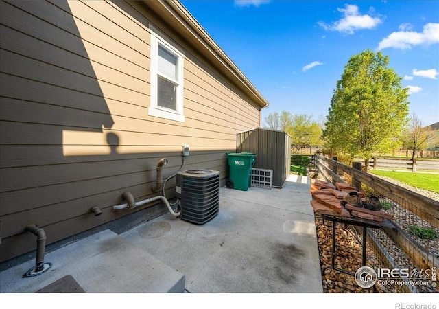 view of patio / terrace featuring central air condition unit and fence