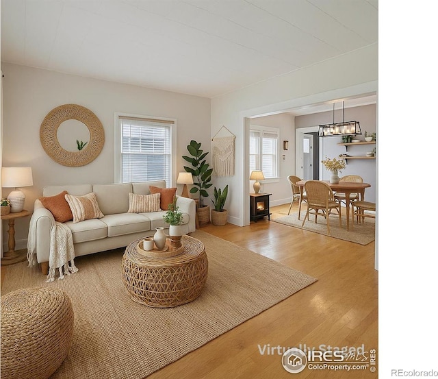 405 Maple St, Fort Morgan, CO 80701 - living room with plenty of natural light, wood finished floors, baseboards, and a chandelier