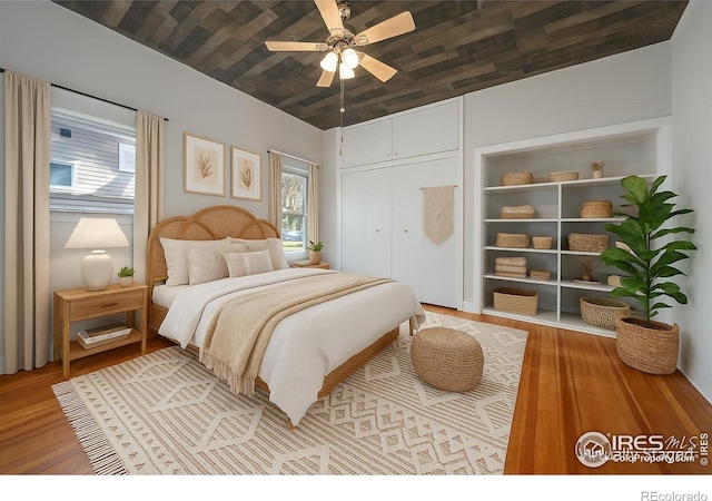 405 Maple St, Fort Morgan, CO 80701 - bedroom featuring wood finished floors, multiple windows, a closet, and ceiling fan